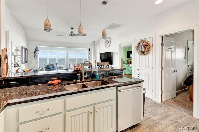 kitchen with sink, hanging light fixtures, stainless steel dishwasher, ceiling fan, and dark stone counters