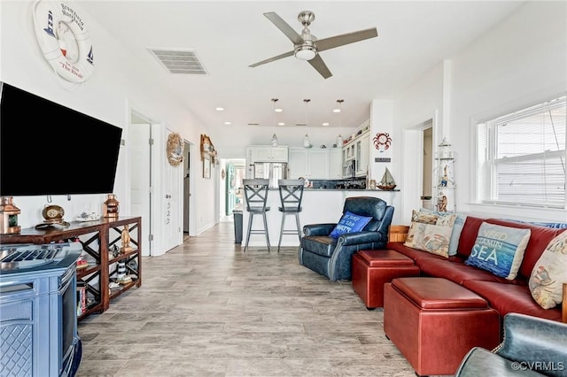 living room with ceiling fan and light wood-type flooring