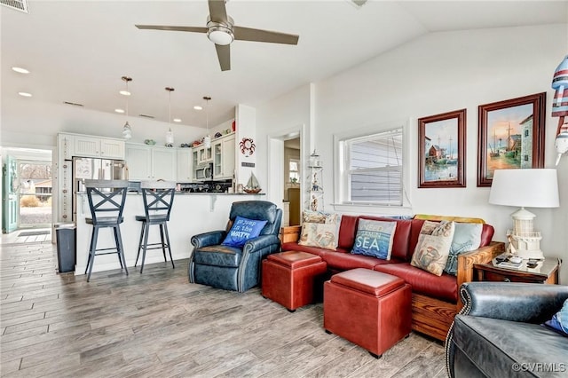 living room featuring ceiling fan, lofted ceiling, and light hardwood / wood-style floors