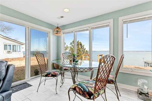 sunroom / solarium featuring a water view