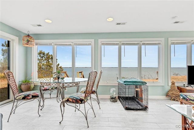 sunroom / solarium with a water view