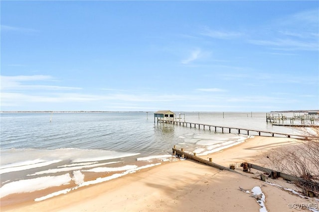 dock area featuring a water view and a beach view