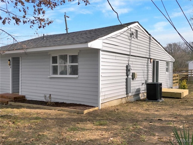 view of property exterior with central AC and a lawn