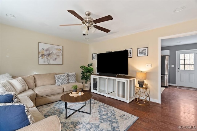 living room with dark wood-type flooring and ceiling fan