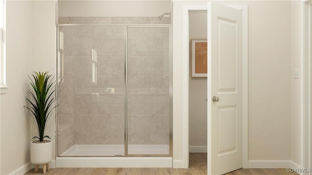 bathroom with hardwood / wood-style flooring and walk in shower