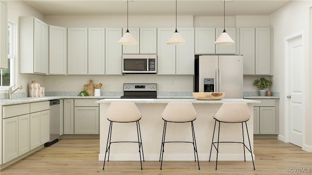 kitchen featuring hanging light fixtures, white cabinetry, appliances with stainless steel finishes, and a center island