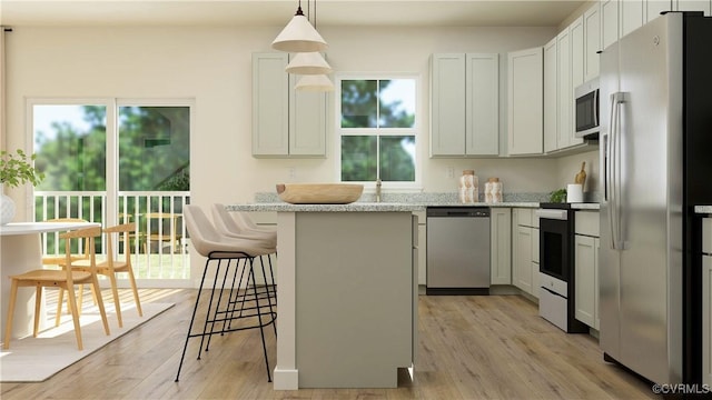 kitchen featuring appliances with stainless steel finishes, white cabinetry, a kitchen breakfast bar, light stone countertops, and decorative light fixtures