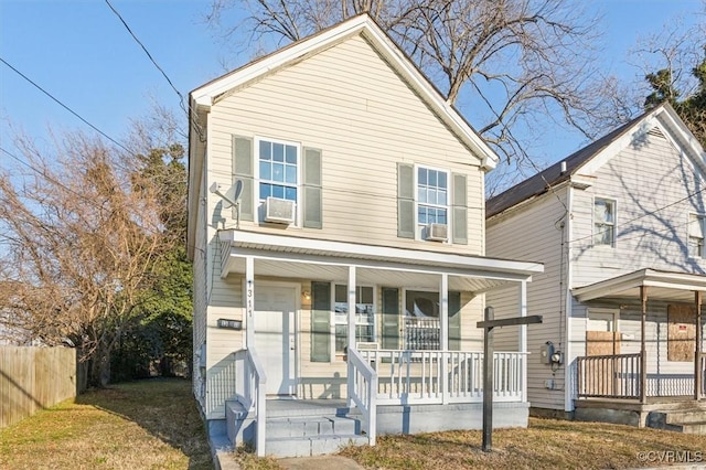 view of property featuring a porch, cooling unit, and a front yard