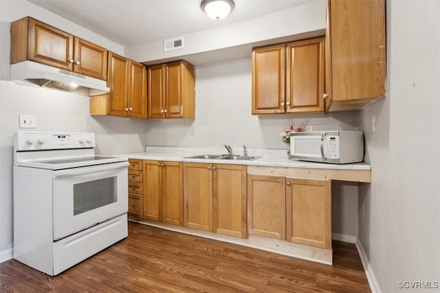 kitchen featuring white appliances, dark hardwood / wood-style floors, and sink