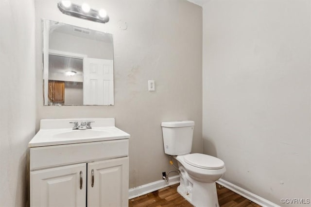 bathroom with vanity, wood-type flooring, and toilet