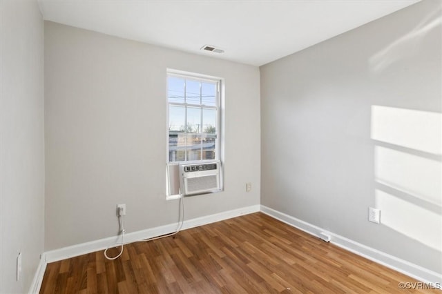 unfurnished room featuring cooling unit and hardwood / wood-style floors