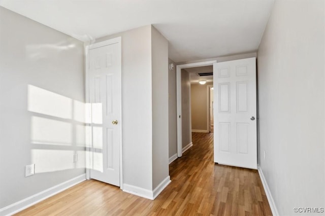 corridor with hardwood / wood-style flooring