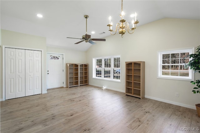 unfurnished living room with lofted ceiling, ceiling fan with notable chandelier, and light hardwood / wood-style flooring