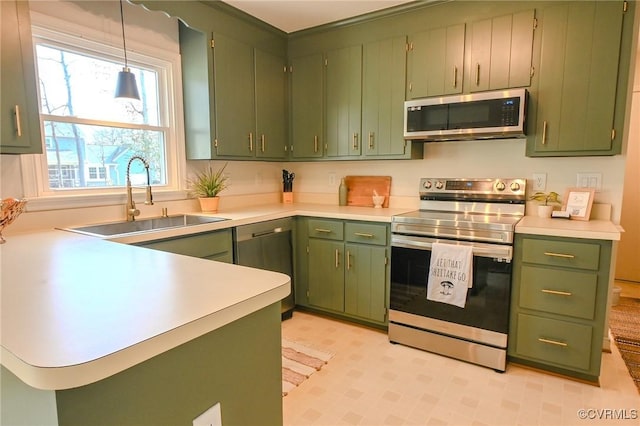 kitchen featuring pendant lighting, sink, stainless steel appliances, and green cabinets