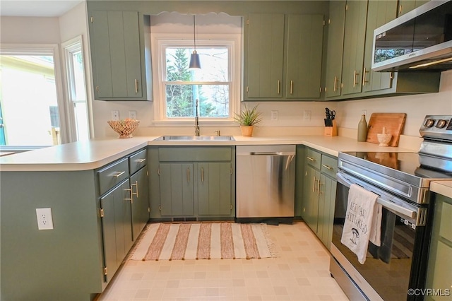 kitchen with appliances with stainless steel finishes, sink, and green cabinets