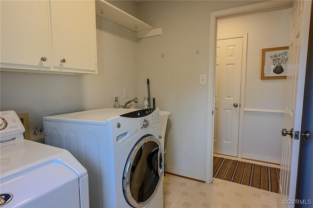 laundry room with washing machine and dryer and cabinets