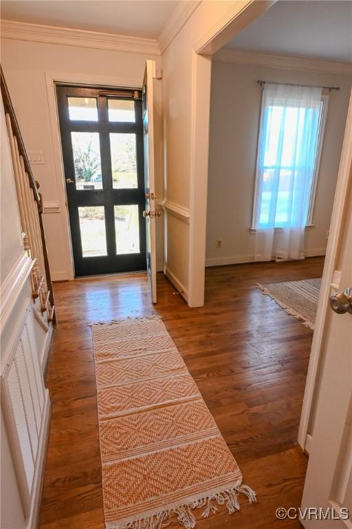 foyer entrance with ornamental molding and hardwood / wood-style floors