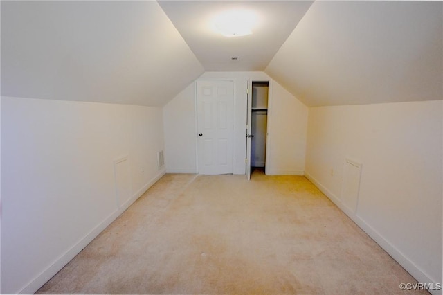 additional living space featuring lofted ceiling and light carpet