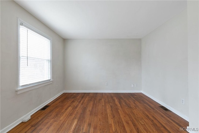 unfurnished room featuring plenty of natural light and dark hardwood / wood-style floors