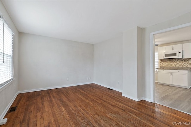 spare room with hardwood / wood-style flooring and a healthy amount of sunlight