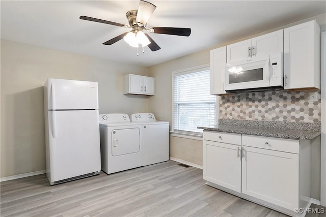 laundry area with ceiling fan, independent washer and dryer, and light hardwood / wood-style flooring