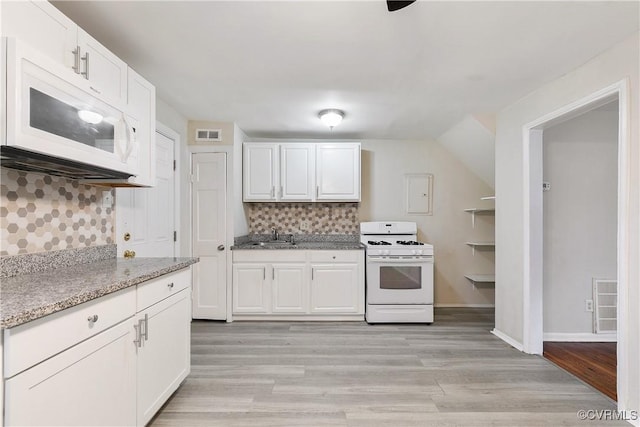 kitchen featuring white appliances, white cabinetry, tasteful backsplash, light stone countertops, and light wood-type flooring