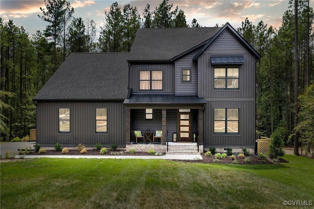 modern inspired farmhouse featuring a yard and covered porch