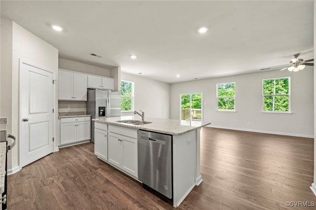 kitchen with sink, appliances with stainless steel finishes, dark hardwood / wood-style floors, white cabinets, and a center island with sink