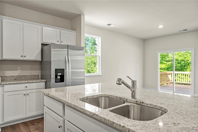 kitchen with white cabinetry, sink, and stainless steel fridge