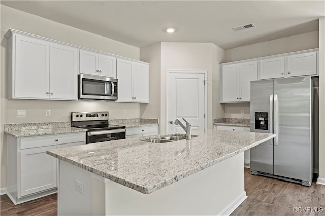 kitchen with sink, stainless steel appliances, an island with sink, and white cabinets