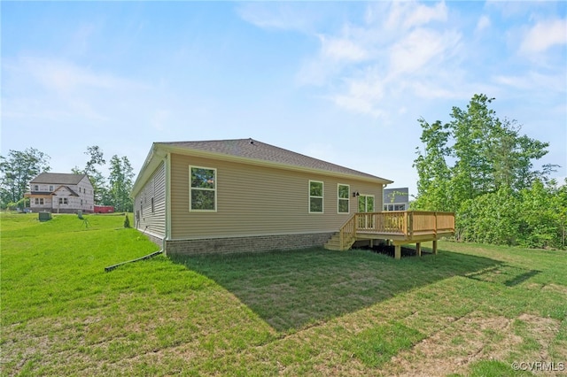 rear view of property with a wooden deck and a yard