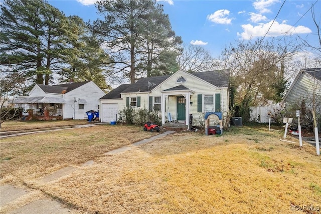 view of front of house with a garage, a front lawn, and central air condition unit