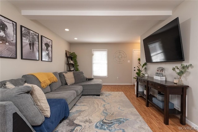 living room featuring beamed ceiling and light wood-type flooring