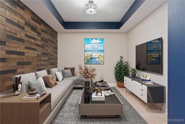 living room with wooden walls and a tray ceiling