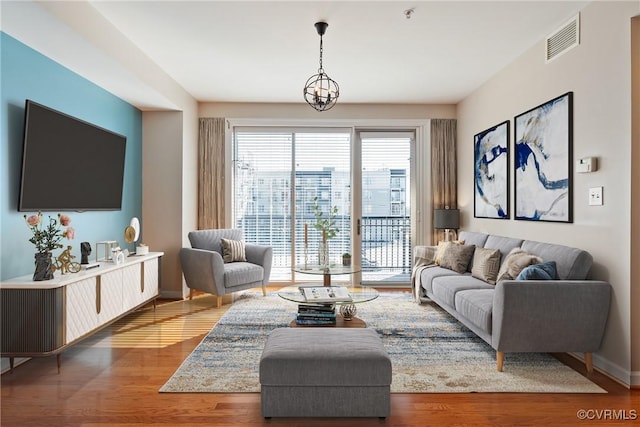 living room with hardwood / wood-style flooring and a notable chandelier