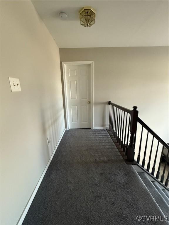 hallway featuring dark carpet