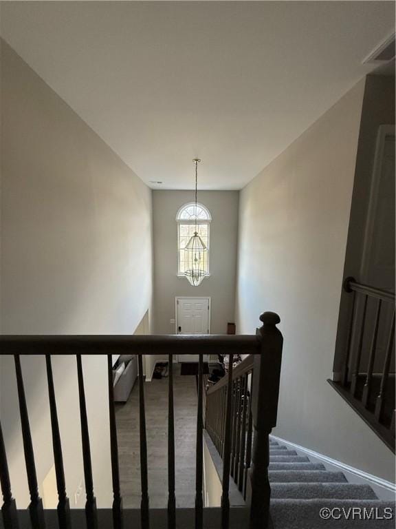 staircase with a chandelier