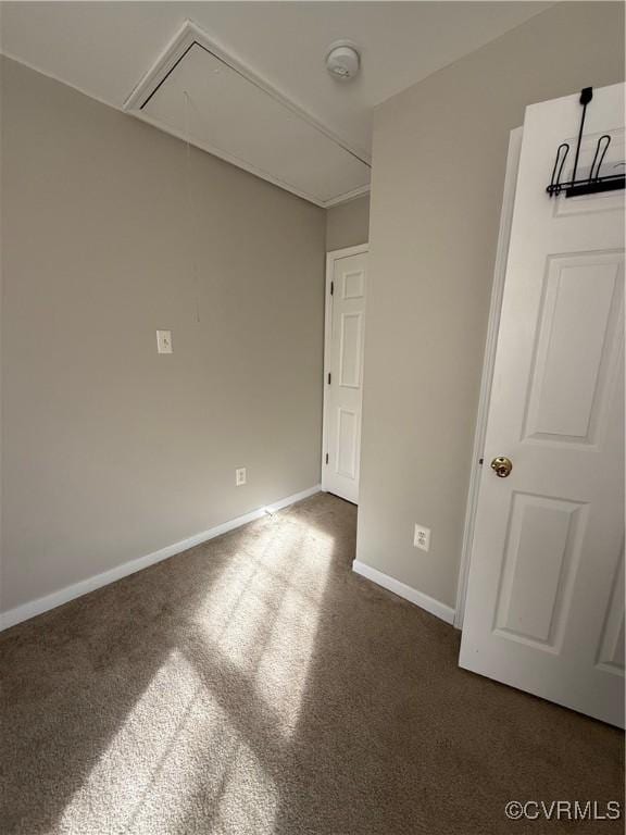 spare room featuring dark carpet