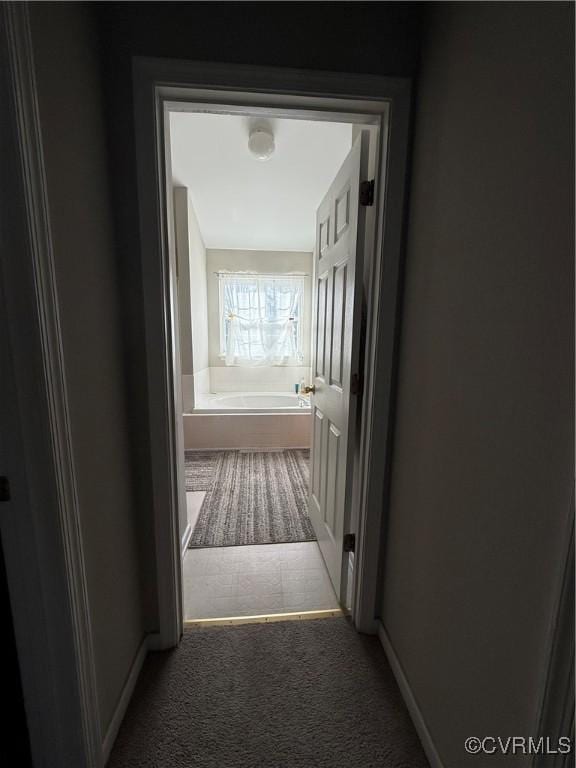 hallway featuring dark colored carpet