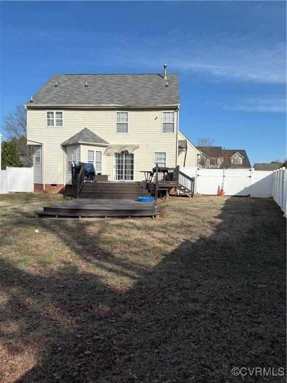 back of property with a wooden deck and a yard