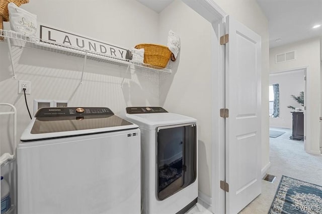 clothes washing area featuring light colored carpet and independent washer and dryer