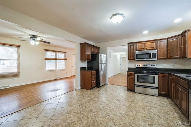 kitchen with ceiling fan, appliances with stainless steel finishes, and light hardwood / wood-style floors