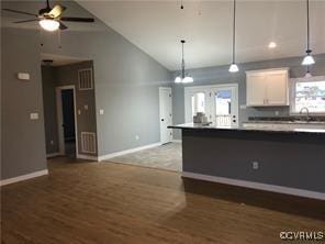 kitchen featuring ceiling fan, lofted ceiling, dark hardwood / wood-style flooring, and white cabinets