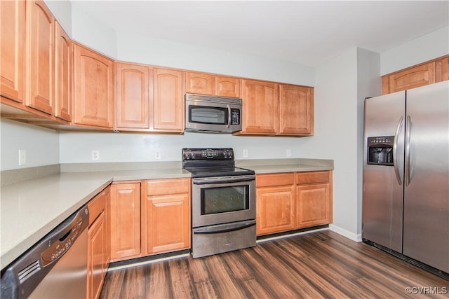 kitchen featuring appliances with stainless steel finishes and dark hardwood / wood-style flooring