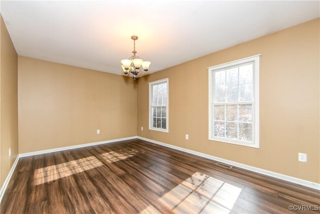 unfurnished room with dark hardwood / wood-style floors and a chandelier