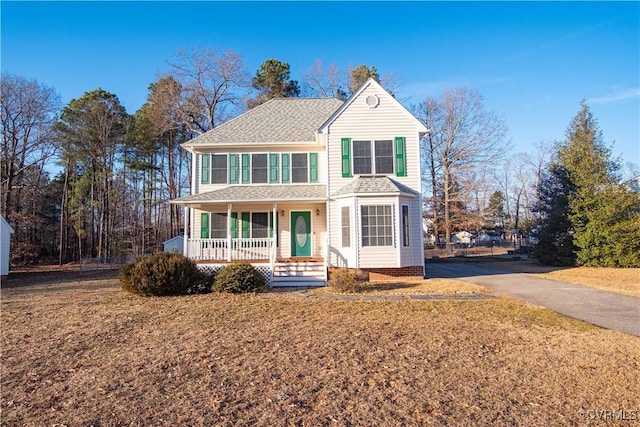 view of front of house with a porch and a front yard