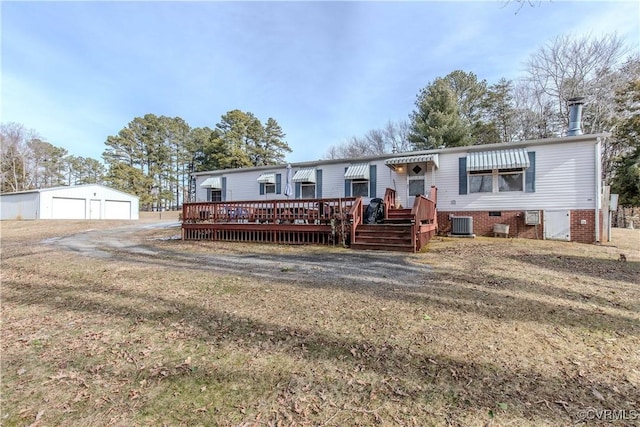 view of front facade featuring a wooden deck, a garage, an outdoor structure, central AC unit, and a front yard