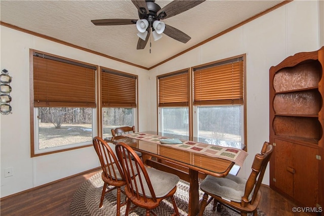 dining space with vaulted ceiling, plenty of natural light, dark hardwood / wood-style floors, and ornamental molding