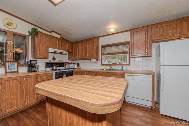 kitchen with sink, white appliances, dark wood-type flooring, tasteful backsplash, and a textured ceiling