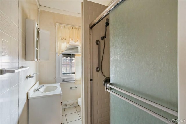 bathroom featuring tile patterned floors, toilet, a shower with shower door, tile walls, and vanity